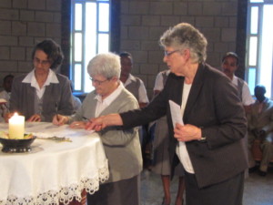 Missionary Sisters sign documents at vows ceremony. 